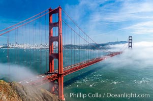 San Franciscos infamous summer fog overtakes the Golden Gate Bridge, viewed from the Marin Headlands with the city of San Francisco visible in the distance