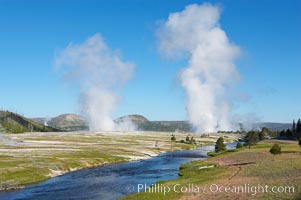 Steam rises above the Midway Geyser Basin, largely from Grand Prismatic Spring and Excelsior Geyser. The Firehole River flows by.
