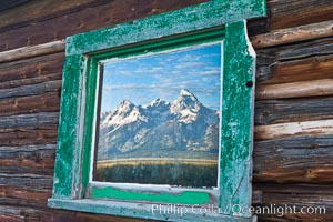 Teton Range reflection, in window of old barn in Grand Teton National Park.