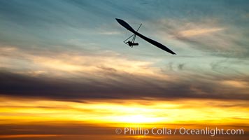 Hang Glider soaring at Torrey Pines Gliderport, sunset, flying over the Pacific Ocean, La Jolla, California