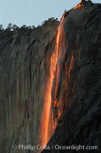 Horsetail Falls backlit by the setting sun as it cascades down the face of El Capitan, February, Yosemite Valley, Yosemite National Park, California