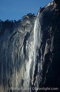 Horsetail Falls backlit by the setting sun as it cascades down the face of El Capitan, February, Yosemite Valley, Yosemite National Park, California