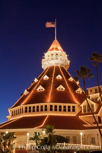 Hotel del Coronado with holiday Christmas night lights, known affectionately as the Hotel Del. It was once the largest hotel in the world, and is one of the few remaining wooden Victorian beach resorts. It sits on the beach on Coronado Island, seen here with downtown San Diego in the distance. It is widely considered to be one of Americas most beautiful and classic hotels. Built in 1888, it was designated a National Historic Landmark in 1977