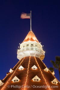 Hotel del Coronado with holiday Christmas night lights, known affectionately as the Hotel Del. It was once the largest hotel in the world, and is one of the few remaining wooden Victorian beach resorts. It sits on the beach on Coronado Island, seen here with downtown San Diego in the distance. It is widely considered to be one of Americas most beautiful and classic hotels. Built in 1888, it was designated a National Historic Landmark in 1977