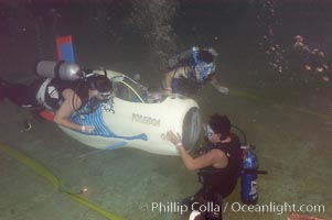 Student engineers prepare a human-powered submarine for an underwater time trial.  The submarines pilot and source of power is visible in the cockpit, and breathes on SCUBA while operating the sub.  The submersible was designed, built and operated by High Tech High School (San Diego, California) engineering students, Offshore Model Basin, Escondido