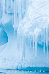 Icicles and melting ice, hanging from the edge of an blue iceberg.