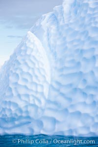 Iceberg with scalloped erosion.  The eroded indentations on this iceberg were melted when this portion of the iceberg was underwater.  As it melted, the iceberg grew topheavy, eventually flipping and exposing this interesting surface.