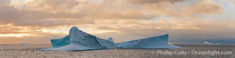 Iceberg panoramic photo.  Iceberg, ocean, light and clouds. Light plays over icebergs and the ocean near Coronation Island.