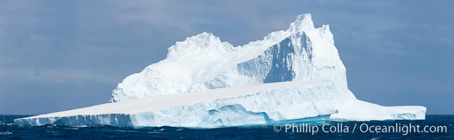 Iceberg panoramic photo.  Iceberg, ocean, light and clouds. Light plays over icebergs and the ocean near Coronation Island.