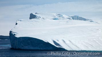 Iceberg and snow-covered coastline, Antarctic Sound