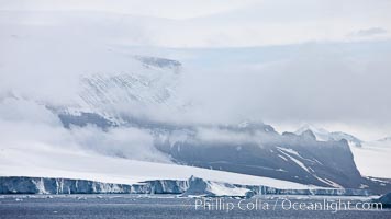 Iceberg and snow-covered coastline, Antarctic Sound