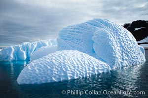 Iceberg with scalloped erosion.  The eroded indentations on this iceberg were melted when this portion of the iceberg was underwater.  As it melted, the iceberg grew topheavy, eventually flipping and exposing this interesting surface, Paulet Island