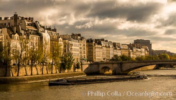 River Seine, barge and Ile Saint-Louis, sunrise, Paris. Ile Saint-Louis, is one of two natural islands in the Seine river, in Paris, France. The island is named after King Louis IX of France (Saint Louis). The island is connected to the rest of Paris by bridges to both banks of the river and by the Pont Saint Louis to the Ile de la Cite