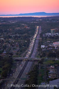 Interstate 805, rushhour traffic at sunset, looking north with the hills of Camp Pendleton and Oceanside in the distance.