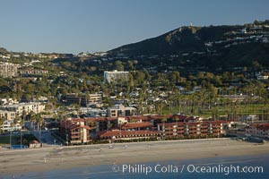 La Jolla Shores Beach, with the La Jolla Shores Hotel fronting the flat sand beach.  Mount Soledad rises in the background