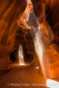 Light Beam in Upper Antelope Slot Canyon.  Thin shafts of light briefly penetrate the convoluted narrows of Upper Antelope Slot Canyon, sending piercing beams through the sandstone maze to the sand floor below. Navajo Tribal Lands, Page, Arizona, USA, natural history stock photograph, photo id 28561