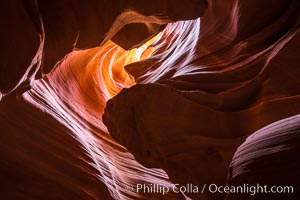 Light Beam in Upper Antelope Slot Canyon.  Thin shafts of light briefly penetrate the convoluted narrows of Upper Antelope Slot Canyon, sending piercing beams through the sandstone maze to the sand floor below, Navajo Tribal Lands, Page, Arizona