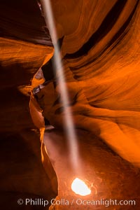 Light Beam in Upper Antelope Slot Canyon.  Thin shafts of light briefly penetrate the convoluted narrows of Upper Antelope Slot Canyon, sending piercing beams through the sandstone maze to the sand floor below, Navajo Tribal Lands, Page, Arizona