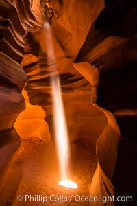 Light Beam in Upper Antelope Slot Canyon.  Thin shafts of light briefly penetrate the convoluted narrows of Upper Antelope Slot Canyon, sending piercing beams through the sandstone maze to the sand floor below, Navajo Tribal Lands, Page, Arizona