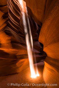 Light Beam in Upper Antelope Slot Canyon.  Thin shafts of light briefly penetrate the convoluted narrows of Upper Antelope Slot Canyon, sending piercing beams through the sandstone maze to the sand floor below, Navajo Tribal Lands, Page, Arizona