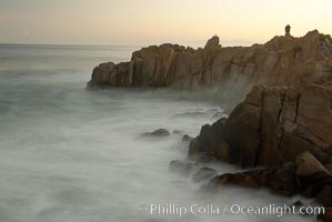 Lovers Point, Pacific Grove.  A couple admires the sunrise atop Lovers Point in Pacific Grove.  Waves breaking over rocks appear as a foggy mist in this time exposure.  Pacific Grove