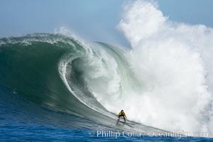 2006 Mavericks surf contest champion Grant Twiggy Baker of South Africa catches one of his many great waves of the day, this one in the first round.  Check out the huge bounce lifting up behind him, heavy.  Mavericks surf contest, February 7, 2006, Half Moon Bay, California