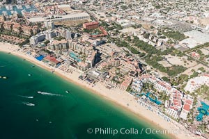 Aerial view of Medano Beach in Cabo San Lucas, showing many resorts along the long white sand beach