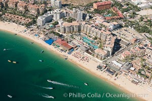 Aerial view of Medano Beach in Cabo San Lucas, showing many resorts along the long white sand beach