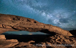 The Milky Way arching over Mesa Arch at night.