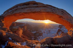 Mesa Arch spans 90 feet and stands at the edge of a mesa precipice thousands of feet above the Colorado River gorge. For a few moments at sunrise the underside of the arch glows dramatically red and orange, Island in the Sky, Canyonlands National Park, Utah