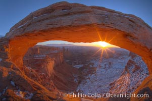 Mesa Arch spans 90 feet and stands at the edge of a mesa precipice thousands of feet above the Colorado River gorge. For a few moments at sunrise the underside of the arch glows dramatically red and orange, Island in the Sky, Canyonlands National Park, Utah