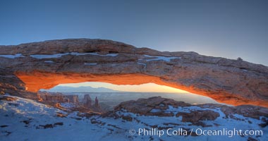 Mesa Arch spans 90 feet and stands at the edge of a mesa precipice thousands of feet above the Colorado River gorge. For a few moments at sunrise the underside of the arch glows dramatically red and orange, Island in the Sky, Canyonlands National Park, Utah