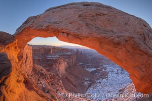 Mesa Arch spans 90 feet and stands at the edge of a mesa precipice thousands of feet above the Colorado River gorge. For a few moments at sunrise the underside of the arch glows dramatically red and orange, Island in the Sky, Canyonlands National Park, Utah