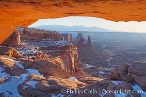 Mesa Arch spans 90 feet and stands at the edge of a mesa precipice thousands of feet above the Colorado River gorge. For a few moments at sunrise the underside of the arch glows dramatically red and orange, Island in the Sky, Canyonlands National Park, Utah