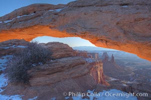 Mesa Arch spans 90 feet and stands at the edge of a mesa precipice thousands of feet above the Colorado River gorge. For a few moments at sunrise the underside of the arch glows dramatically red and orange, Island in the Sky, Canyonlands National Park, Utah