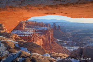 Mesa Arch spans 90 feet and stands at the edge of a mesa precipice thousands of feet above the Colorado River gorge. For a few moments at sunrise the underside of the arch glows dramatically red and orange, Island in the Sky, Canyonlands National Park, Utah