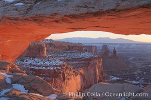 Mesa Arch spans 90 feet and stands at the edge of a mesa precipice thousands of feet above the Colorado River gorge. For a few moments at sunrise the underside of the arch glows dramatically red and orange, Island in the Sky, Canyonlands National Park, Utah