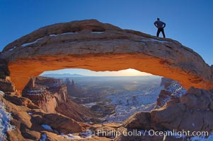 Mesa Arch, Utah.  An hiker watches the dawning sun from atop Mesa Arch, Island in the Sky, Canyonlands National Park