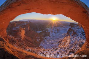 Mesa Arch spans 90 feet and stands at the edge of a mesa precipice thousands of feet above the Colorado River gorge. For a few moments at sunrise the underside of the arch glows dramatically red and orange, Island in the Sky, Canyonlands National Park, Utah