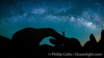 The Milky Way galaxy arcs over Arch Rock in Joshua Tree National Park.