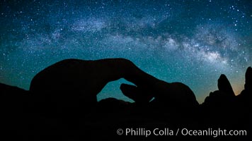 The Milky Way galaxy arches over Arch Rock on a clear evening in Joshua Tree National Park