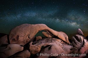 The Milky Way galaxy arches over Arch Rock on a clear evening in Joshua Tree National Park