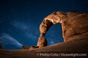 Milky Way arches over Delicate Arch, as stars cover the night sky.