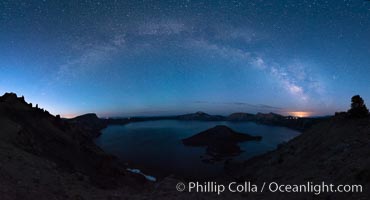 Milky Way and stars over Crater Lake at night. Panorama of Crater Lake and Wizard Island at night, Crater Lake National Park