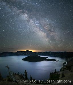 Milky Way and stars over Crater Lake at night. Panorama of Crater Lake and Wizard Island at night, Crater Lake National Park.