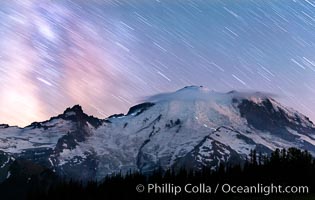 Moutain climbers light see upon Mount Rainier, Milky Way and stars at night above Mount Rainier.
