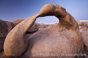 Mobius Arch at sunrise, with Mount Whitney (the tallest peak in the continental United States), Lone Pine Peak and snow-covered Sierra Nevada Range framed within the arch.  Mobius Arch is a 17-foot-wide natural rock arch in the scenic Alabama Hills Recreational Area near Lone Pine, California