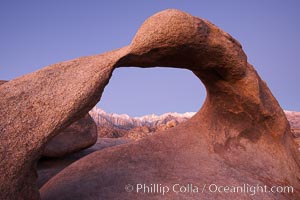 Mobius Arch, with snow covered Mt. Whitney and the Sierra Nevada Range framed within the natural stone arch.  Mt. Whitney is the highest peak in the continental United States, Alabama Hills Recreational Area