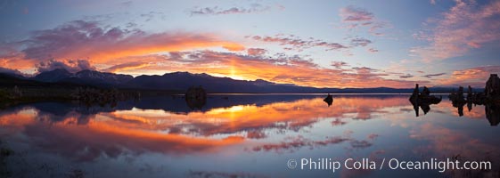 Sun pillar rises over the Sierra Nevada and this Mono Lake sunset, Sierra Nevada mountain range and tufas, clouds reflected in the still waters of Mono Lake