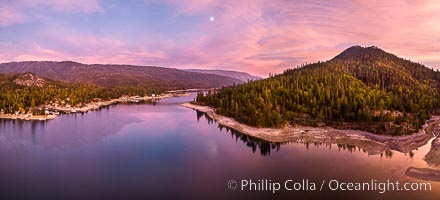 Moonrise and spectacular pink sunset over Bass Lake, Goat Mountain rises to the right, aerial panoramic photo